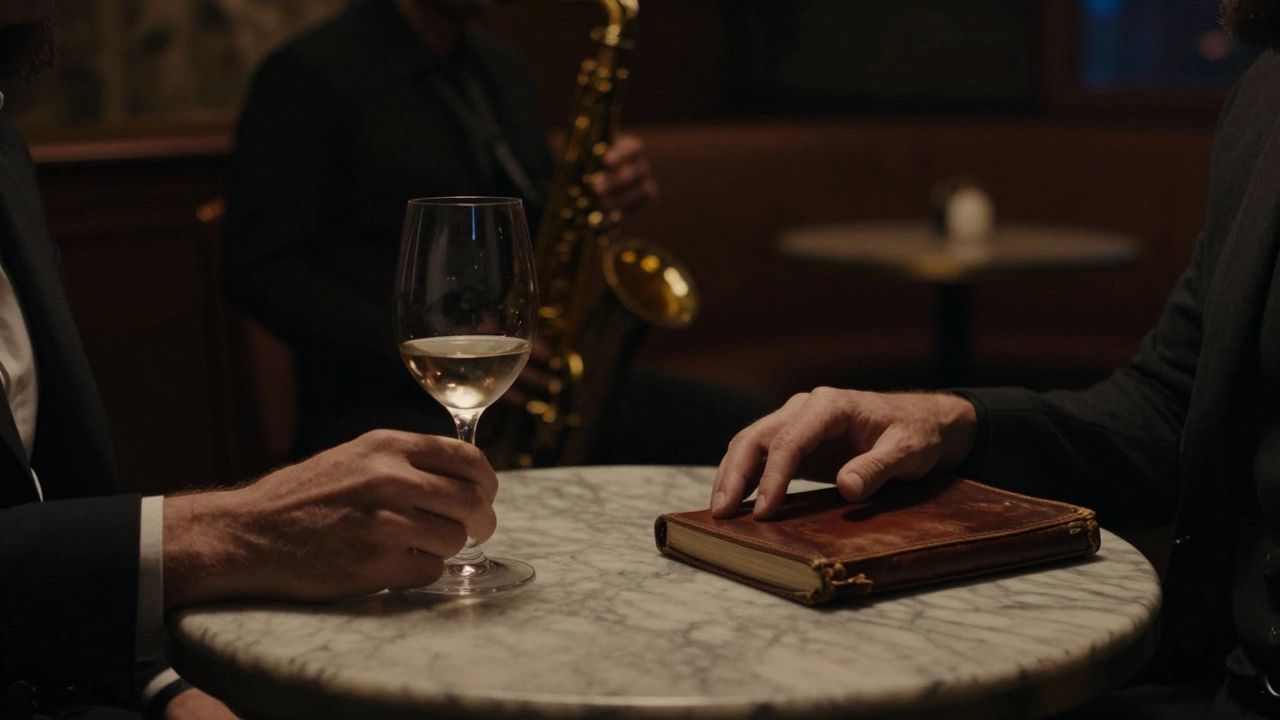 Two hands rest on a marble table in a jazz club, wine glass and journal visible in soft shadowy light.